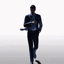 a man in a suit is walking across a white background