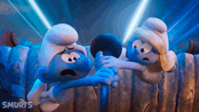 a couple of smurfs standing next to each other with the word smurfs on the bottom