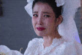 a woman in a wedding dress is crying with tears coming out of her eyes