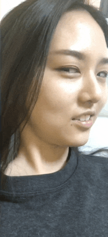 a woman with long black hair is wearing a black shirt