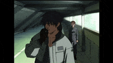 a man talking on a cell phone while another man stands behind him