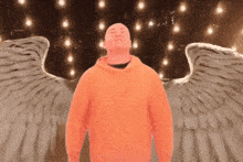 a man in an orange hoodie with angel wings