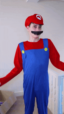 a boy in a mario costume with a red hat and mustache