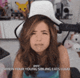a woman sitting in front of a microphone with the words pov when your young sibling eats loud written below her