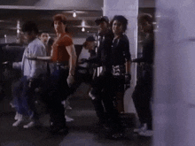 a group of people are standing next to each other in a dark room .