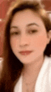 a blurry picture of a woman 's face with long hair and a white shirt .