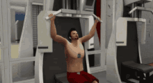 a shirtless man in red shorts is using a machine