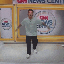 a person is hanging upside down in front of a cnn news center sign