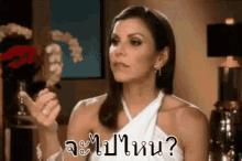 a woman in a white dress is making a funny face and asking a question in thai .