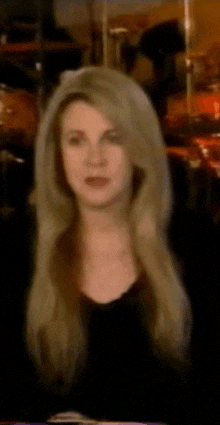 a woman with blonde hair and a black shirt is looking at the camera