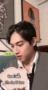 a man wearing a suit and tie is sitting on a couch with a speech bubble that says jin ja mi due