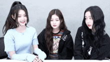 three girls are sitting next to each other with one wearing a sweatshirt that says ' nc ' on it
