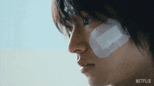 a close up of a person with a bandage on their face and the word netflix on the bottom right