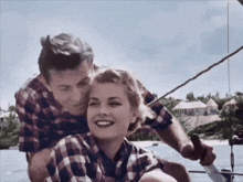 a man and a woman are sitting on a boat and the woman is smiling