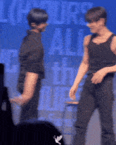a blurry photo of two men dancing in front of a sign that says hours