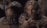 a man with long hair and a beard is talking to a monster