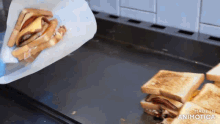 a person is making a grilled cheese sandwich on a griddle