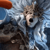 a close up of a statue of a woman with long hair and a crown .