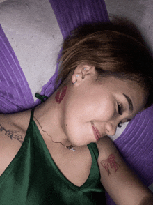 a woman with a butterfly tattoo on her arm is laying on a pillow