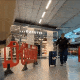 a man pulling a suitcase in front of a sign that says 2 jautri
