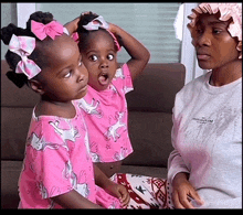 two little girls in pink unicorn pajamas are sitting next to each other