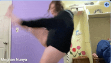 meghan nunya is dancing in a room with a purple door