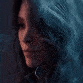 a close up of a woman 's face with long blue hair