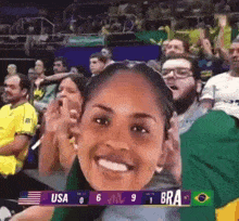 a woman is smiling in front of a screen that says usa 6 jnl 9 bra 1