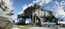 a blue truck is parked in front of a house