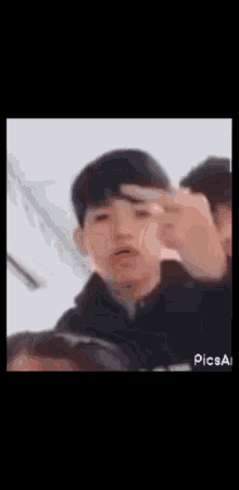 a blurry picture of a boy making a peace sign