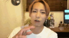 a man in a white shirt is making a gesture