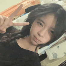 a young girl is giving a peace sign with her fingers