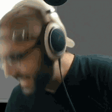 a man with a beard is wearing headphones and a green shirt .