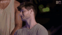 a man with a beard is smiling and looking at the camera while standing next to another man .