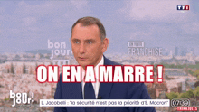 a man in a suit and tie says on en amarre on a tv screen