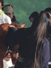 a woman petting a horse with chinese writing on the bottom