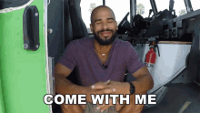 a man in a purple shirt is sitting in a vehicle with the words come with me below him