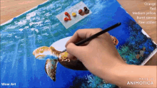 a person is painting a sea turtle with orange red and medium yellow paint