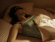 a woman wearing a sleep mask with the word fog on it is laying on a bed