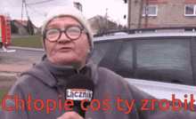 a woman wearing glasses and a hat is holding a microphone with the words chtopia cos ty zrobit written in red