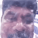a close up of a man 's face with a beard and a blurred background .