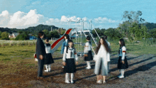 a group of people standing in front of a slide in a field