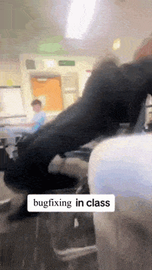 a person is laying on the floor in a classroom with a sign that says bugfixing in class