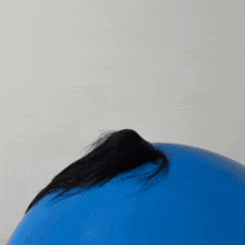 a woman with her hair blowing in the wind is holding a blue ball