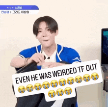 a young man in a blue shirt is holding a sign that says " even he was weirded tf out "