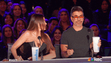 a man and a woman are sitting at a table with lavazza cups on it
