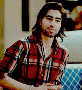 a man wearing a plaid shirt is smiling and looking at the camera