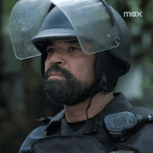 a man with a beard wears a helmet with a clear visor and the word max on the bottom right