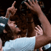 a man wearing a nba hat is holding up a trophy