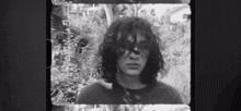 a black and white photo of a man with long hair